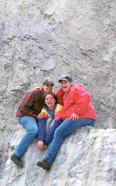 three students on a rock
